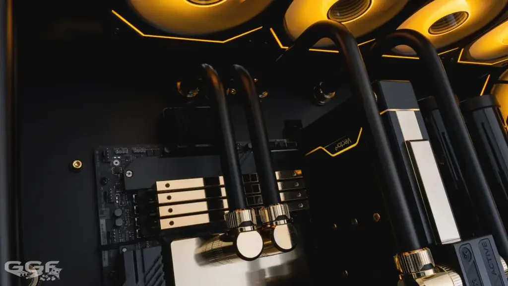 Macro shot of the GPU water block and matte-black tubing with gold accents from the GGF Events Gold Edition build using a Seasonic PRIME 1300W PSU.